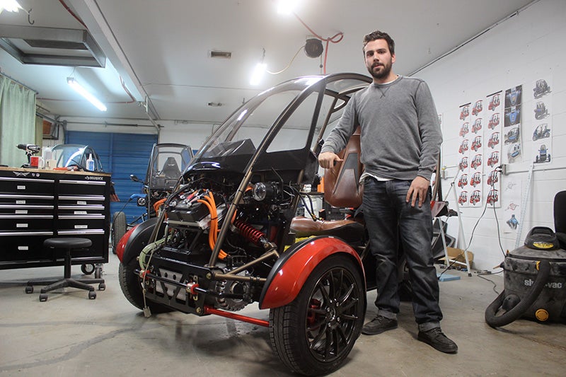 Collin Lafayette stands beside an Arcimoto Gen 8 SRK