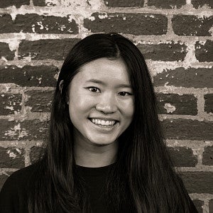 Photograph of a smiling first-year SPD student, Alyssa Tong, in front of a brick wall.
