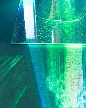 green and blue lights reflect onto floor from shiny object