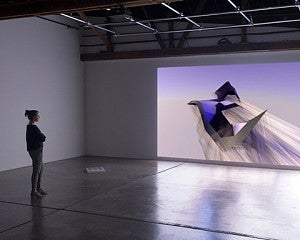 person looks at image projected on wall