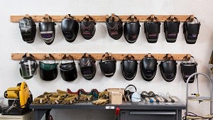 welding helmets hanging on wall