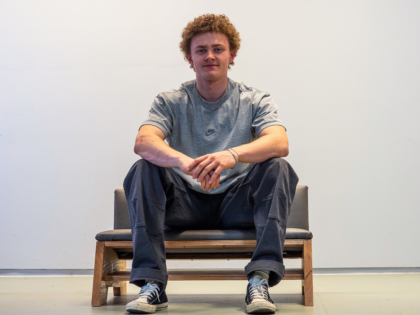 Trent sitting on a chair he designed