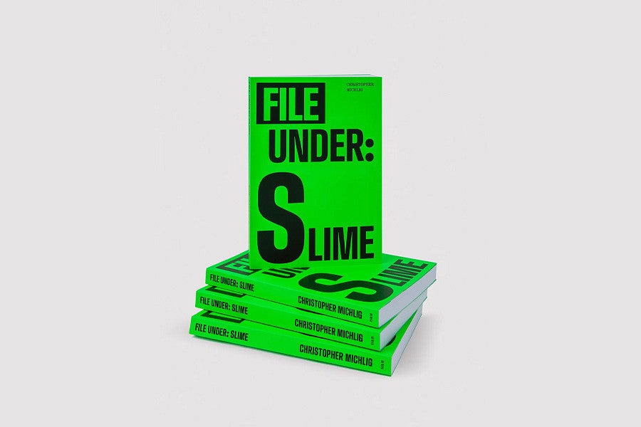 Photo is of the book, "File Under:  Slime", positioned upright on a stack of additional copies of the same book. Book is bright green with the title in simple, black font.