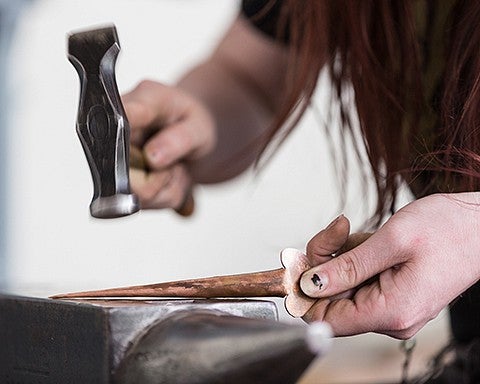 student hammers metal object