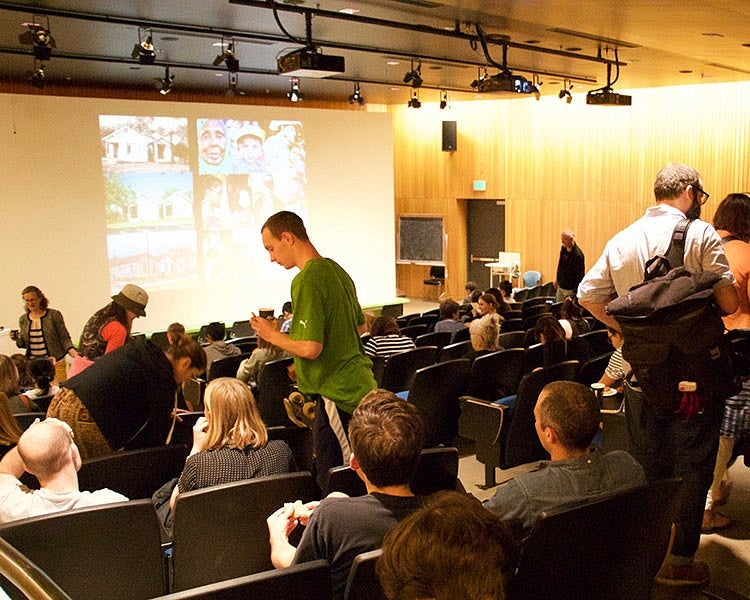 people gather in lecture hall for visiting artist lecture