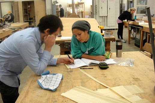 to people work on drawing in notebook in wood shop