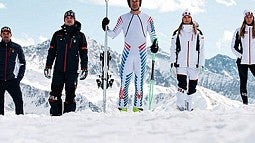 people stand in snow wearing Winter Olympics gear. Image source: The Conversation.