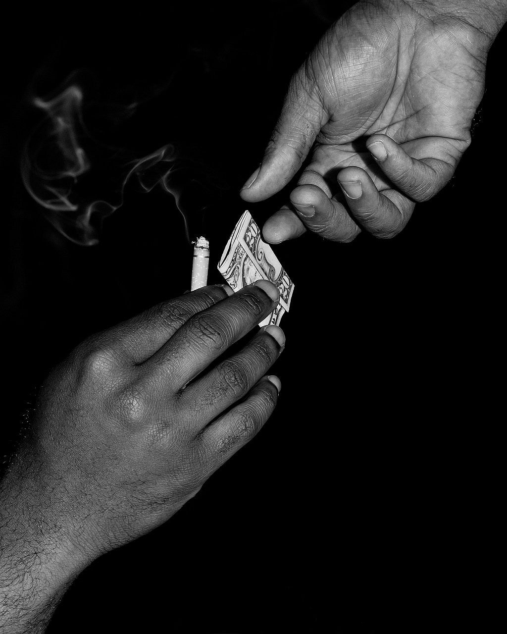 Black and white photograph of two hands exchanging money with one hand holding a cigarette with smoke lines coming off it. 