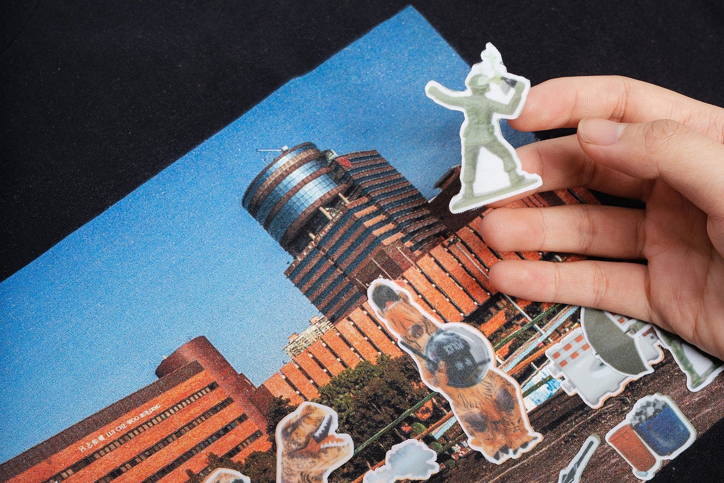 Photograph of a hand playing with cut-out paper toys that look like Hong Kong protesters. 
