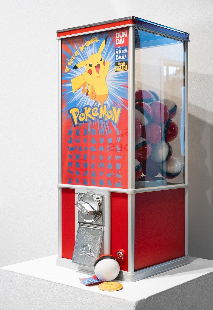 Photograph of a pokemon vending machine with all the pokemon removed from the balls and the machine graphic. 