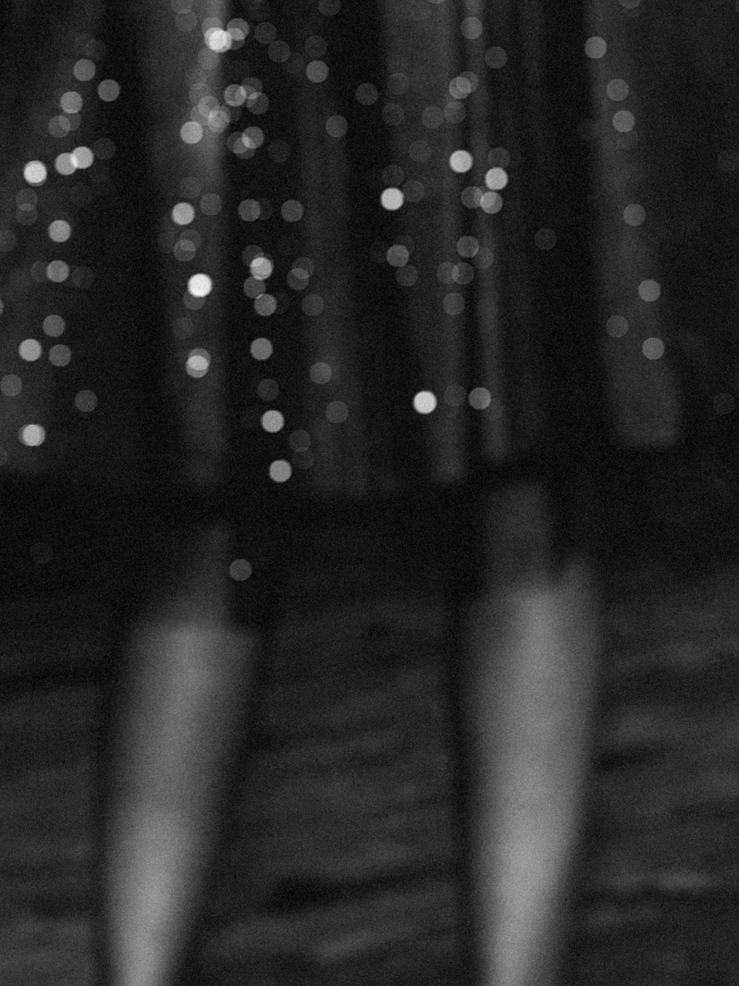 Soft focus black and white photograph of a sparkly skirt with bare legs. 