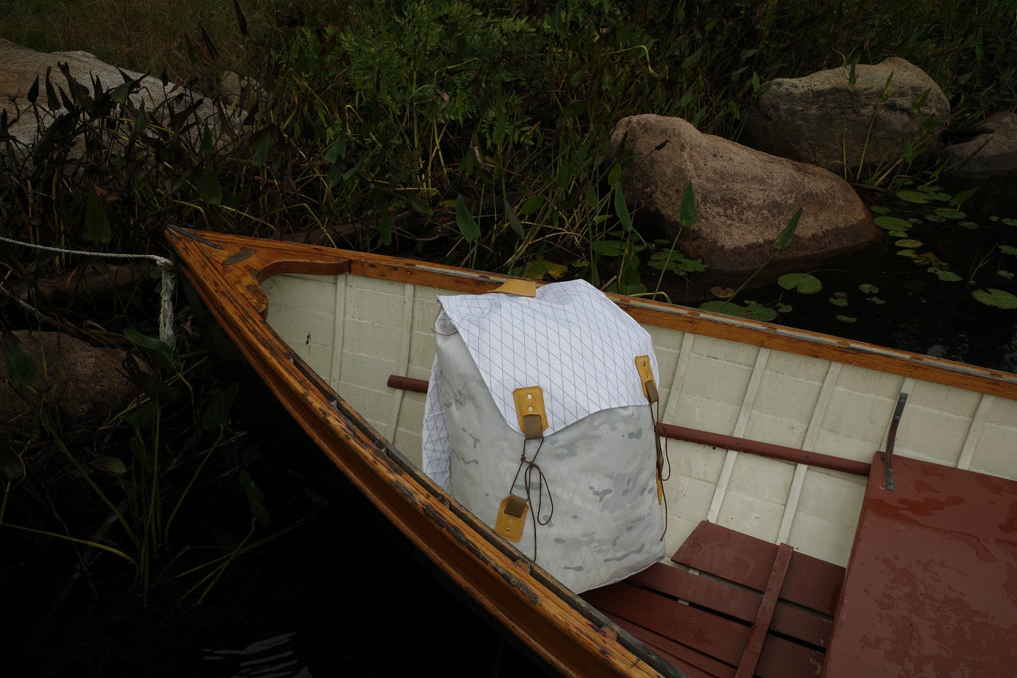 Photograph of a white, custom made backpack in a canoe. 