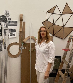 Ido Radon poses along with a smattering of different works in a white room. 
