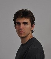 Photograph of a masc presenting person looking into the camera. 