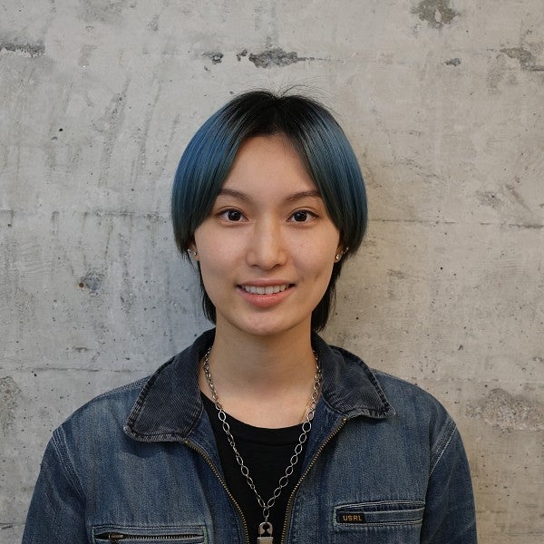 Photograph of Gigi Chen. Shows a smiling individual with short, dark hair, and a smile. 