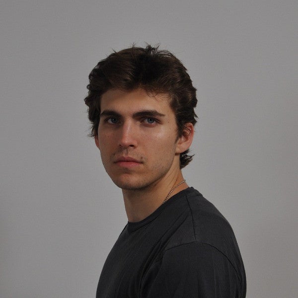 Photograph of a masc presenting person looking into the camera. 
