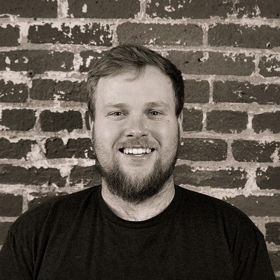 Photograph of a smiling first-year SPD student, Daniel Carhuff, in front of a brick wall.