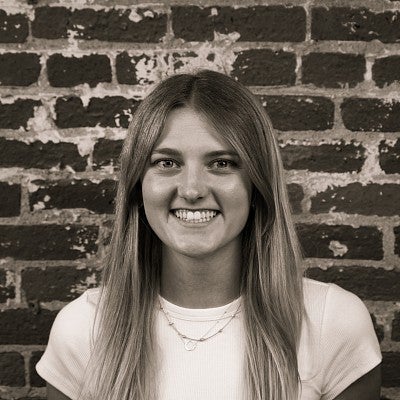 Photograph of a smiling first-year SPD student, Makena Klatt, in front of a brick wall.