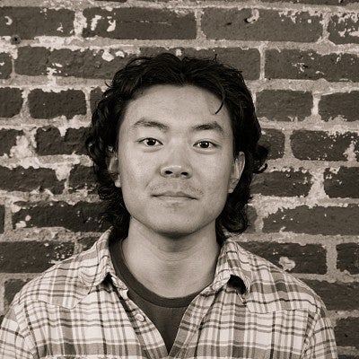 Photograph of a smiling first-year SPD student, Yuxin Mao, in front of a brick wall.