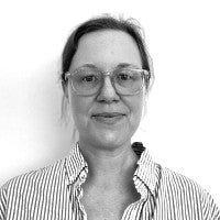 Headshot of the artist, Dawn Cerny. Woman looks into the camera with glasses and hair pulled back. Photo is in black and white. 