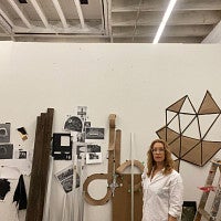 Ido Radon poses along with a smattering of different works in a white room. 